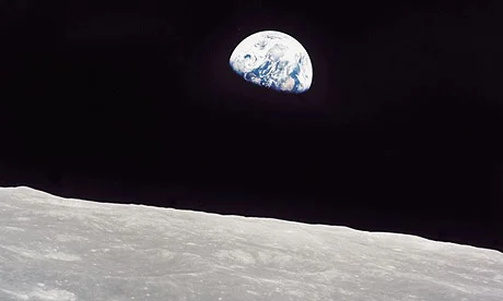 Earth rising above the surface of the Moon